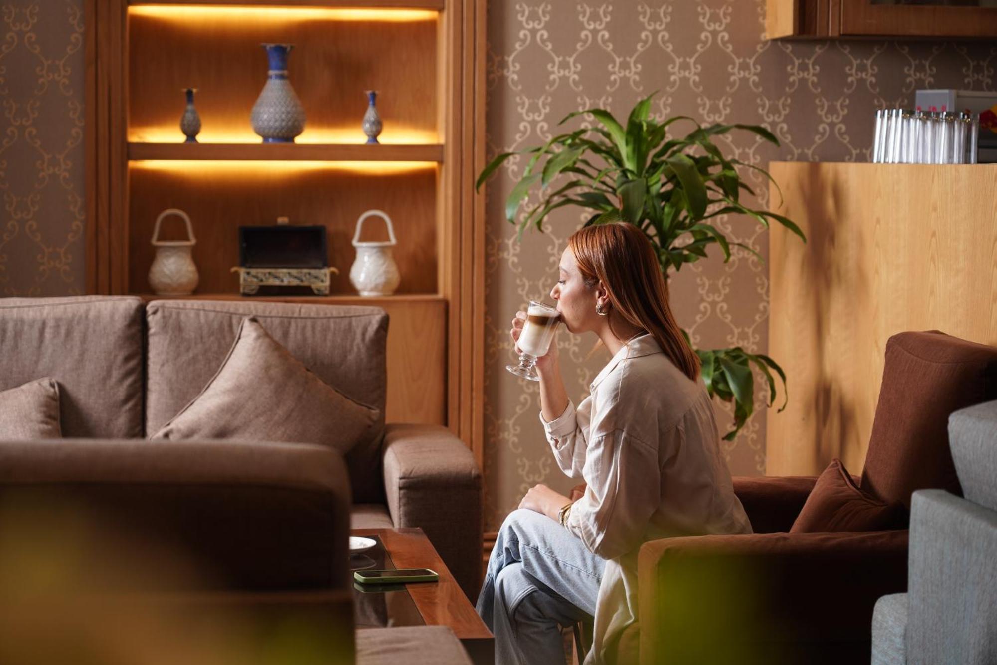 Thousand Nights Hotel Амман Экстерьер фото A woman drinking coffee
